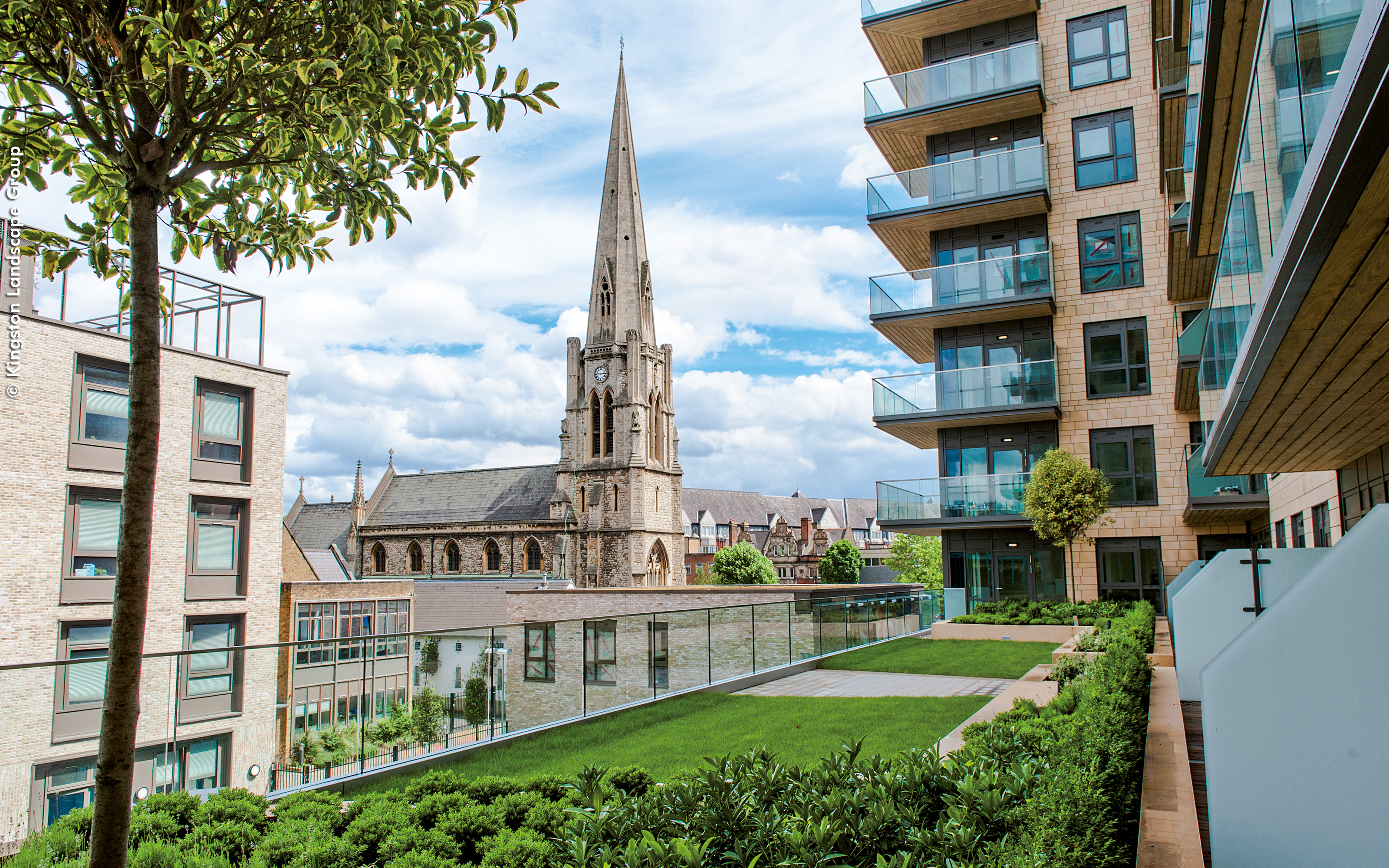 One of the greened roof terraces offers a wonderful view onto the listed Christ the Saviour church. Roof garden with lawn and small trees with a view onto a church